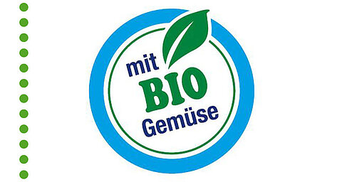 A circular blue and white logo featuring a green leaf and the German text ‘mit BIO Gemüse’ (‘with organic vegetables’) inside.