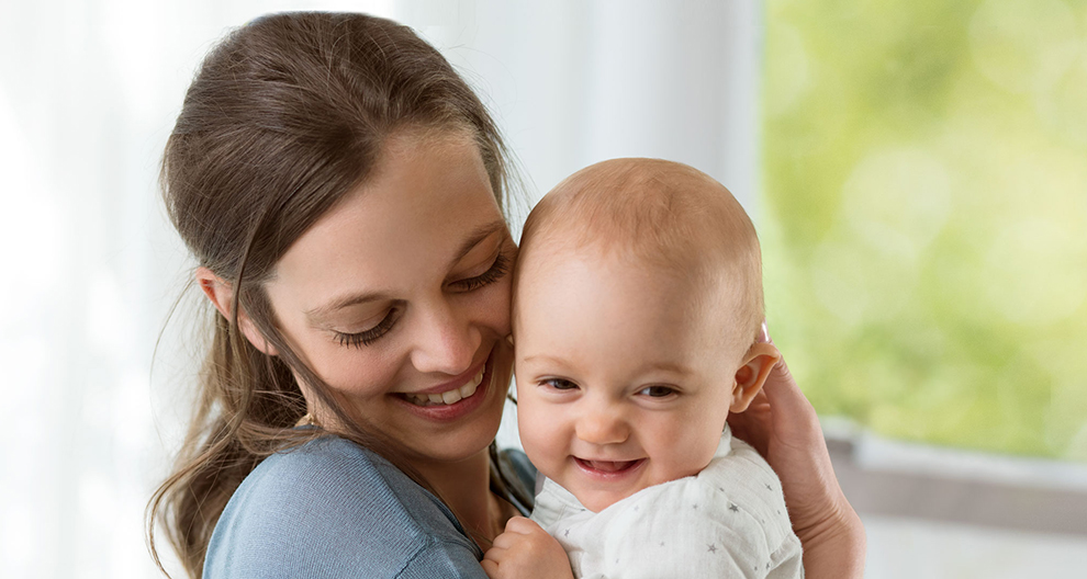 Een vrouw houdt liefdevol een baby vast.