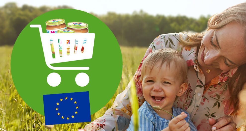 A woman and a child are outdoors, with a shopping cart containing baby food jars and the European Union flag.