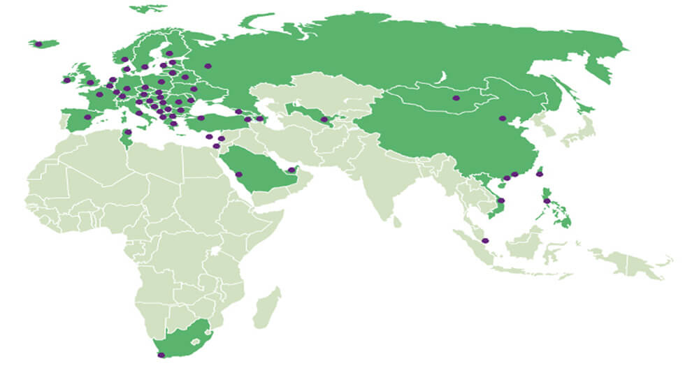 A map of the world with green regions and purple dots scattered across various continents.