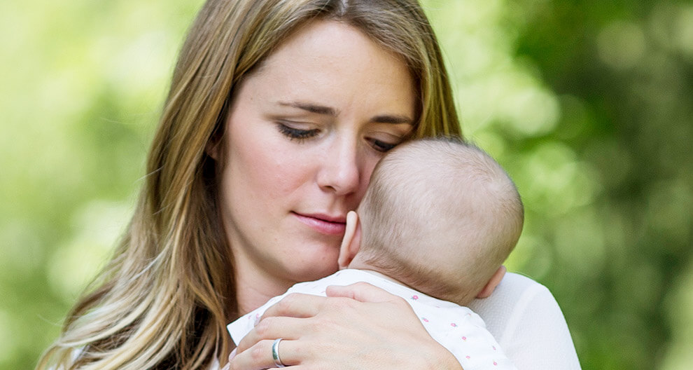 A woman is holding a baby.